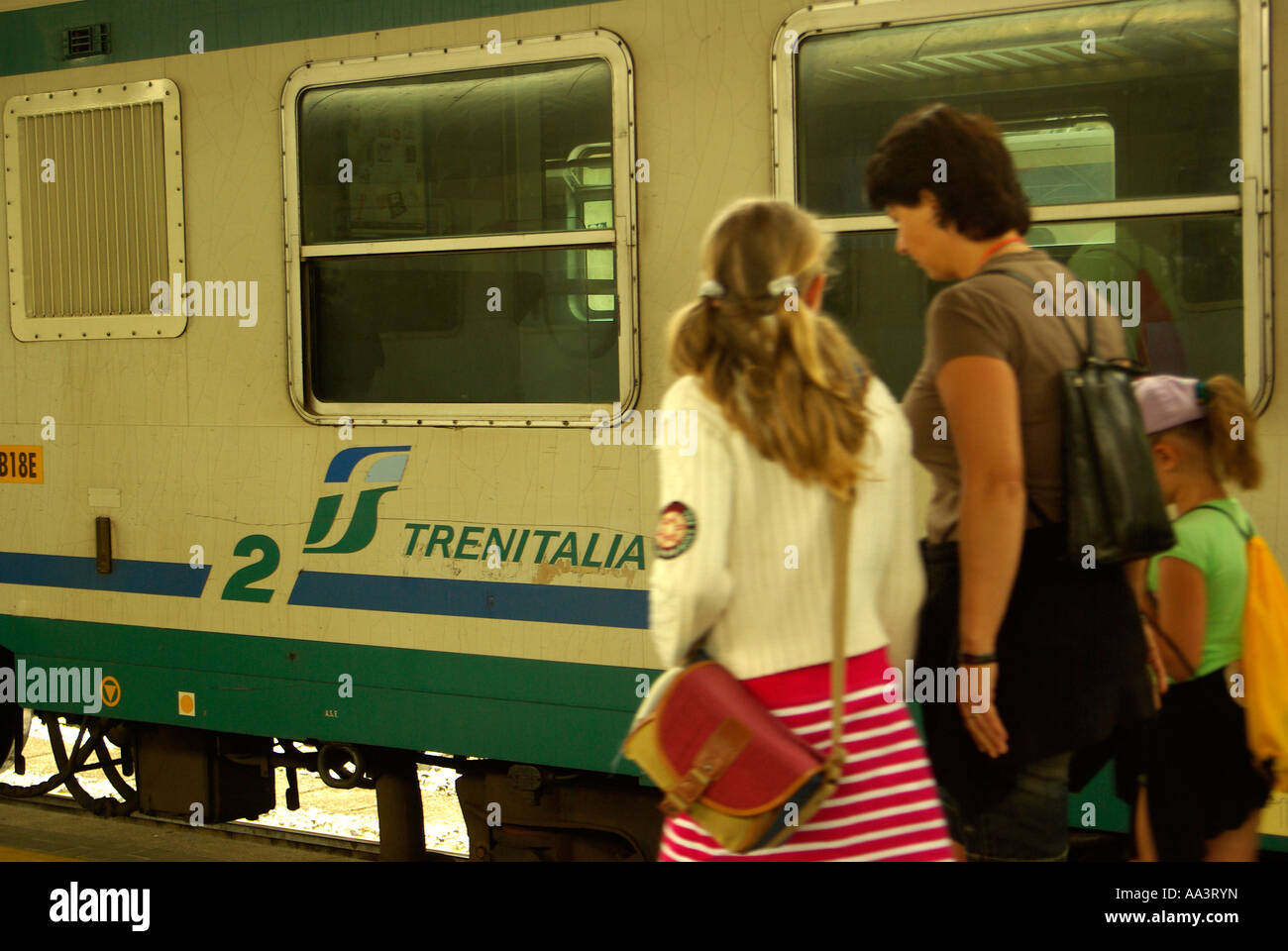 Passengers disembark on the platform at from a Trenitalia Train in Italy Stock Photo