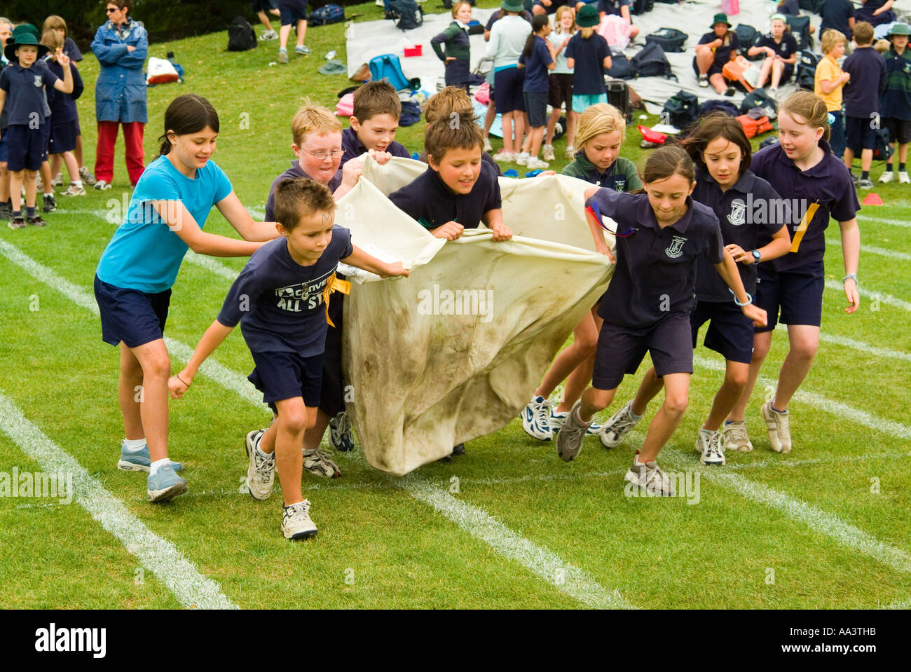 Children running in a sack relay race at primary school sports day in Hobart Tasmania Australia Stock Photo