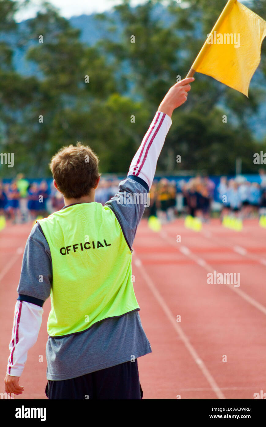 An official at a sporting event waving a yellow flag Stock Photo Alamy