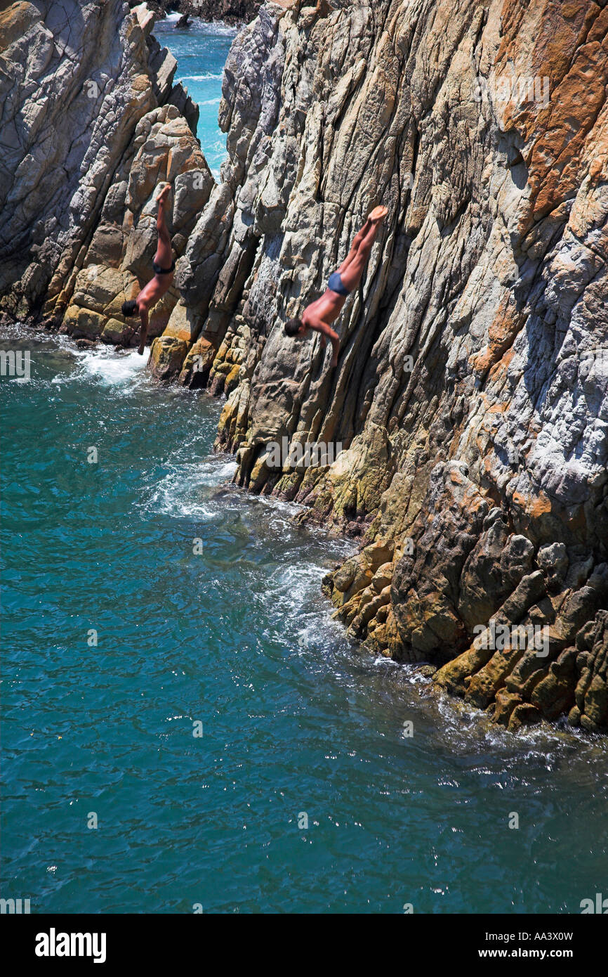 Two cliff divers, clavadistas, diving off the cliffs at La Quebrada, Acapulco, Guerrero State, Mexico Stock Photo