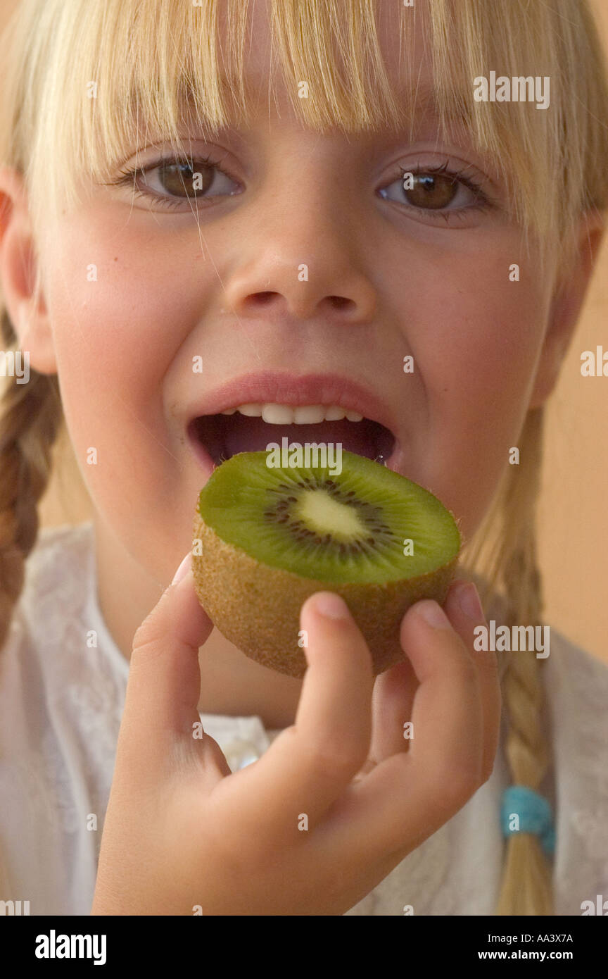young girl eating fruit kiwi Stock Photo Alamy