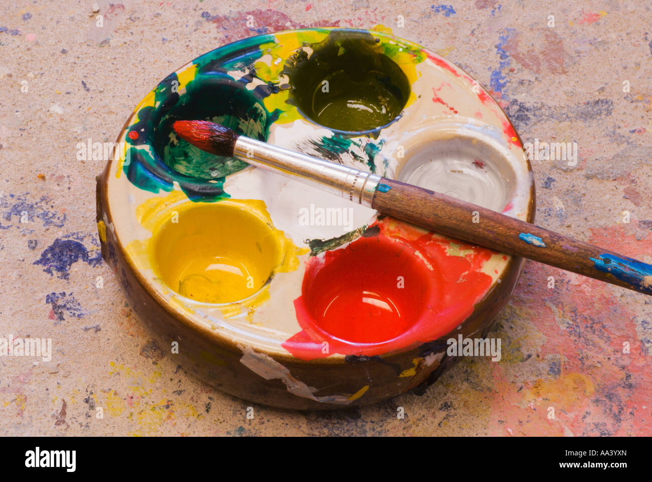 A paint brush and palette with brightly coloured paints Stock Photo - Alamy