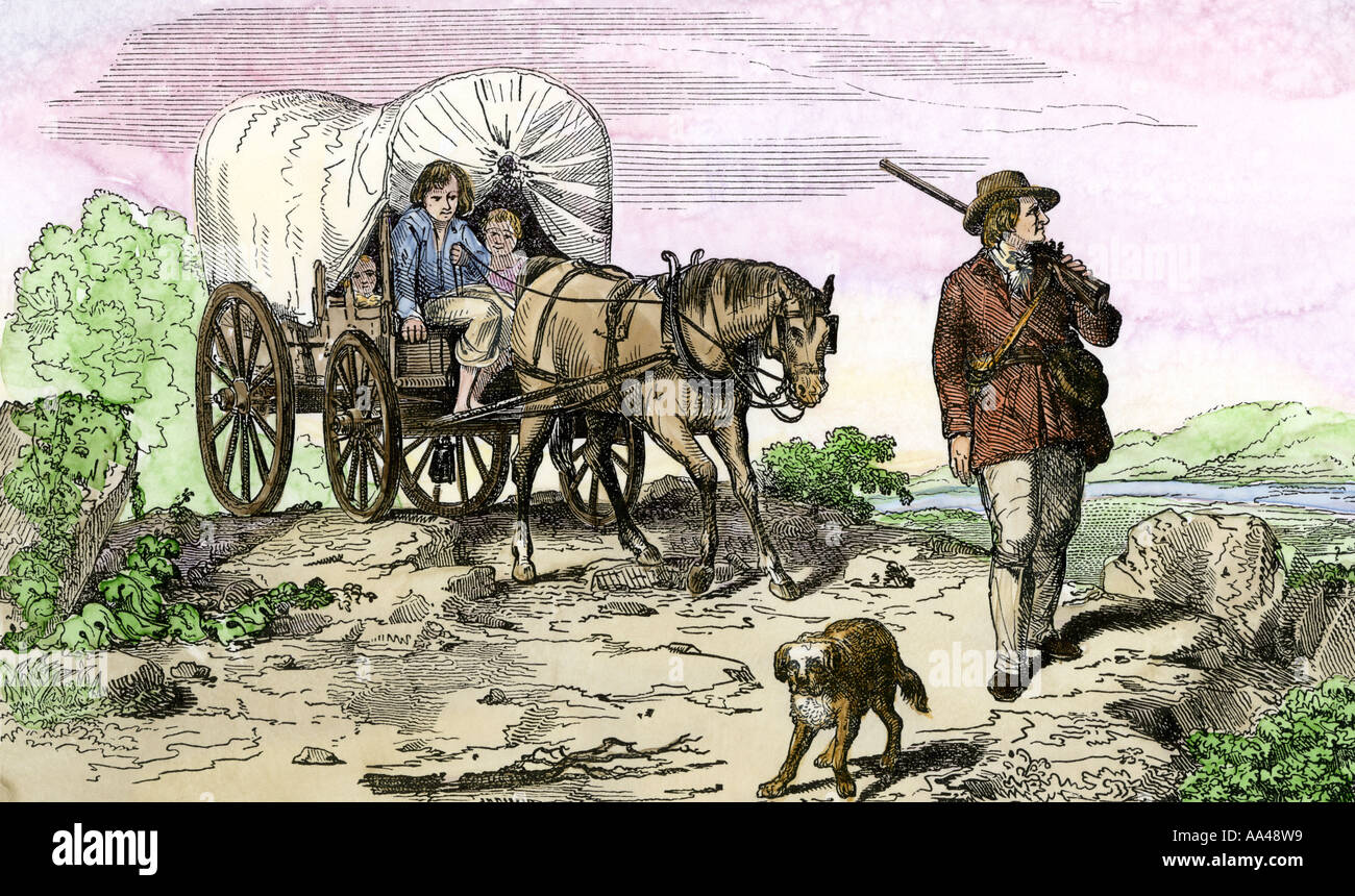 Pioneer family moving west in a covered wagon 1840s. Hand-colored woodcut Stock Photo