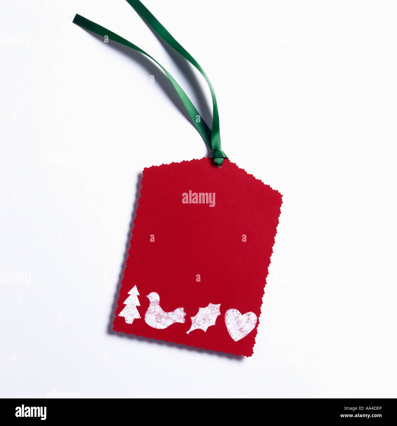 Close-up of red gift tag with white stencilled Christmas motifs Stock Photo