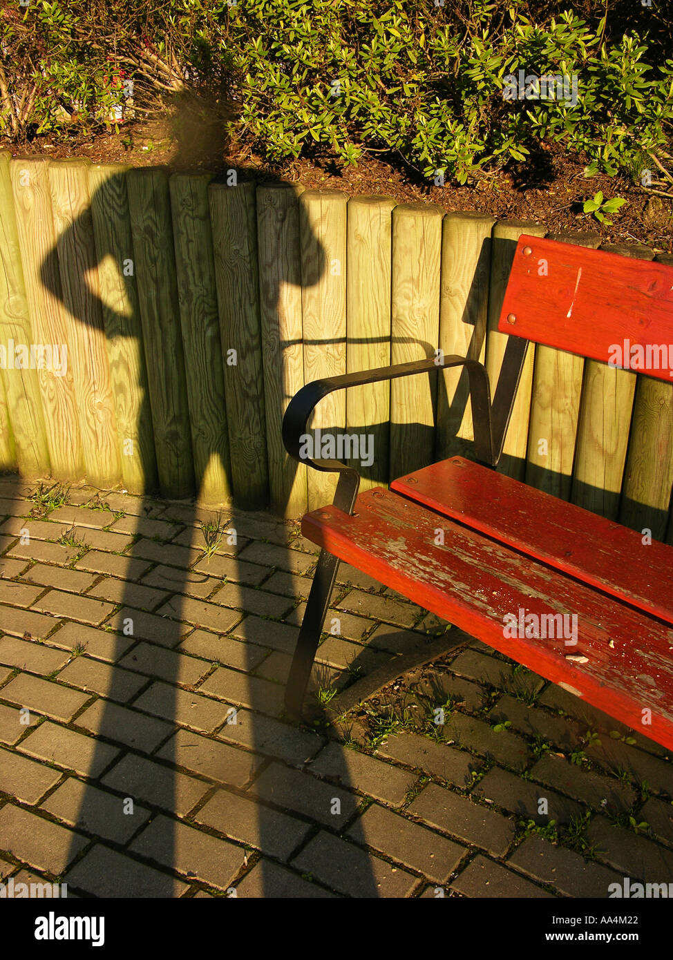 Shadow of a Man and a Park Bench Stock Photo