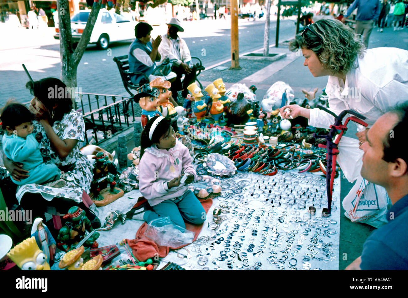 Tijuana Mexico, American Tourist Couple at a Sidewalk Souvenir Vendor Selling Trinkets, Underage Street Vendor Stock Photo