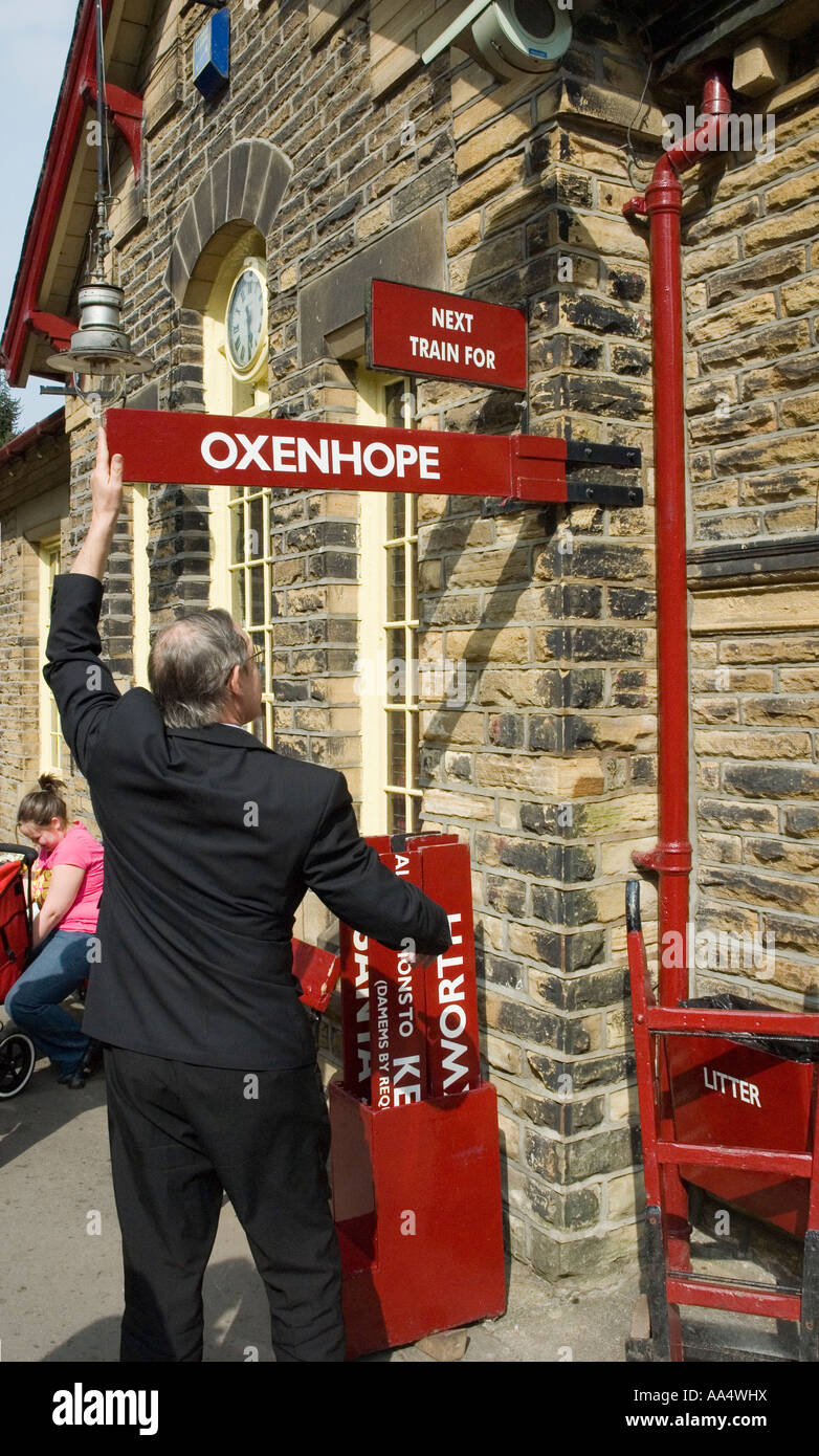 Stationmaster at Haworth Station changing destination board for the Oxenhope train Stock Photo