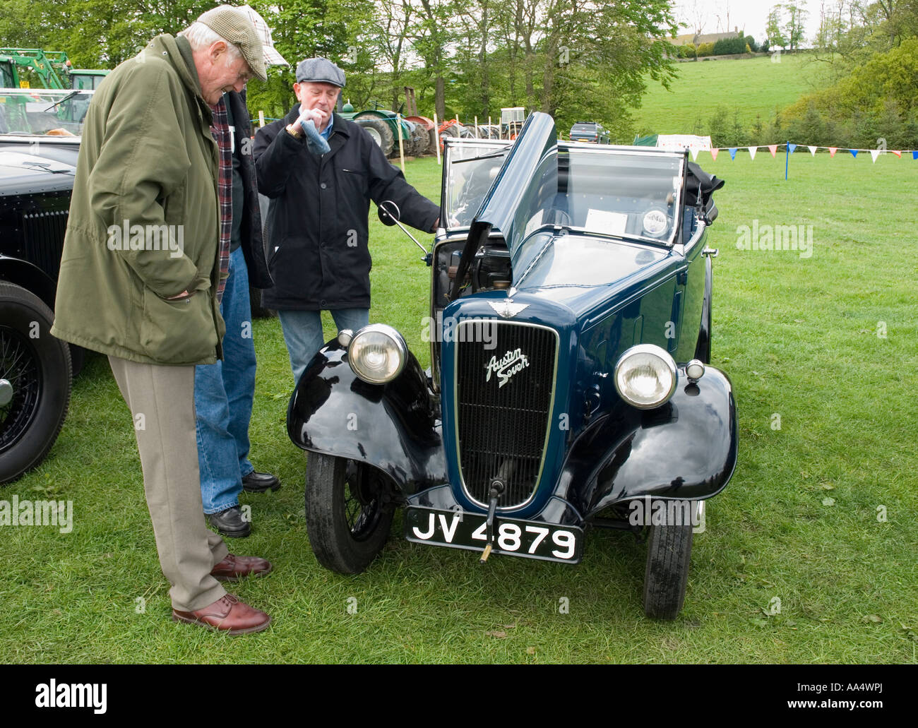 The owner of an Austin 7 talks to other enthuisiasts at a gathering of vintage vehicles Stock Photo