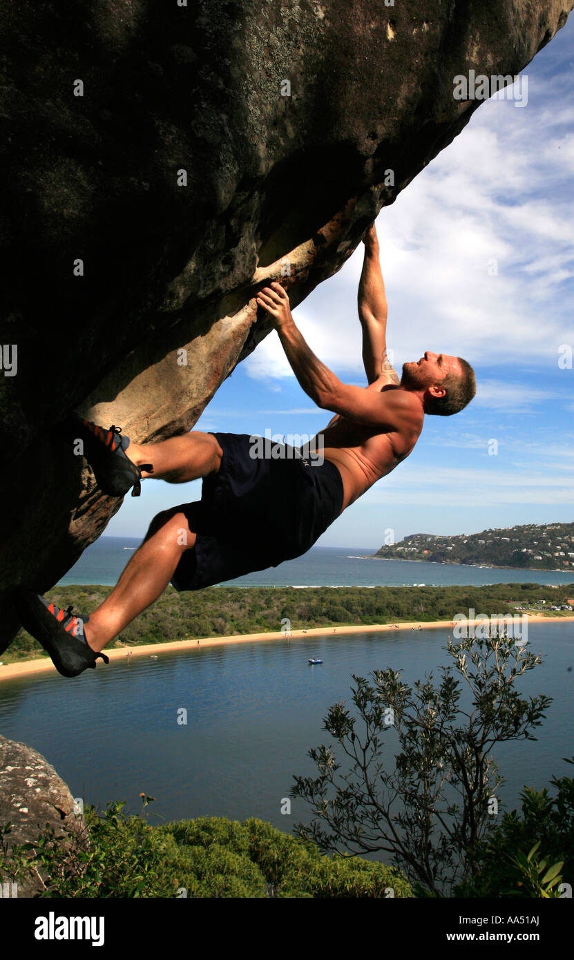 A rock climber makes a free climb ascent above Palm beach Pittwater