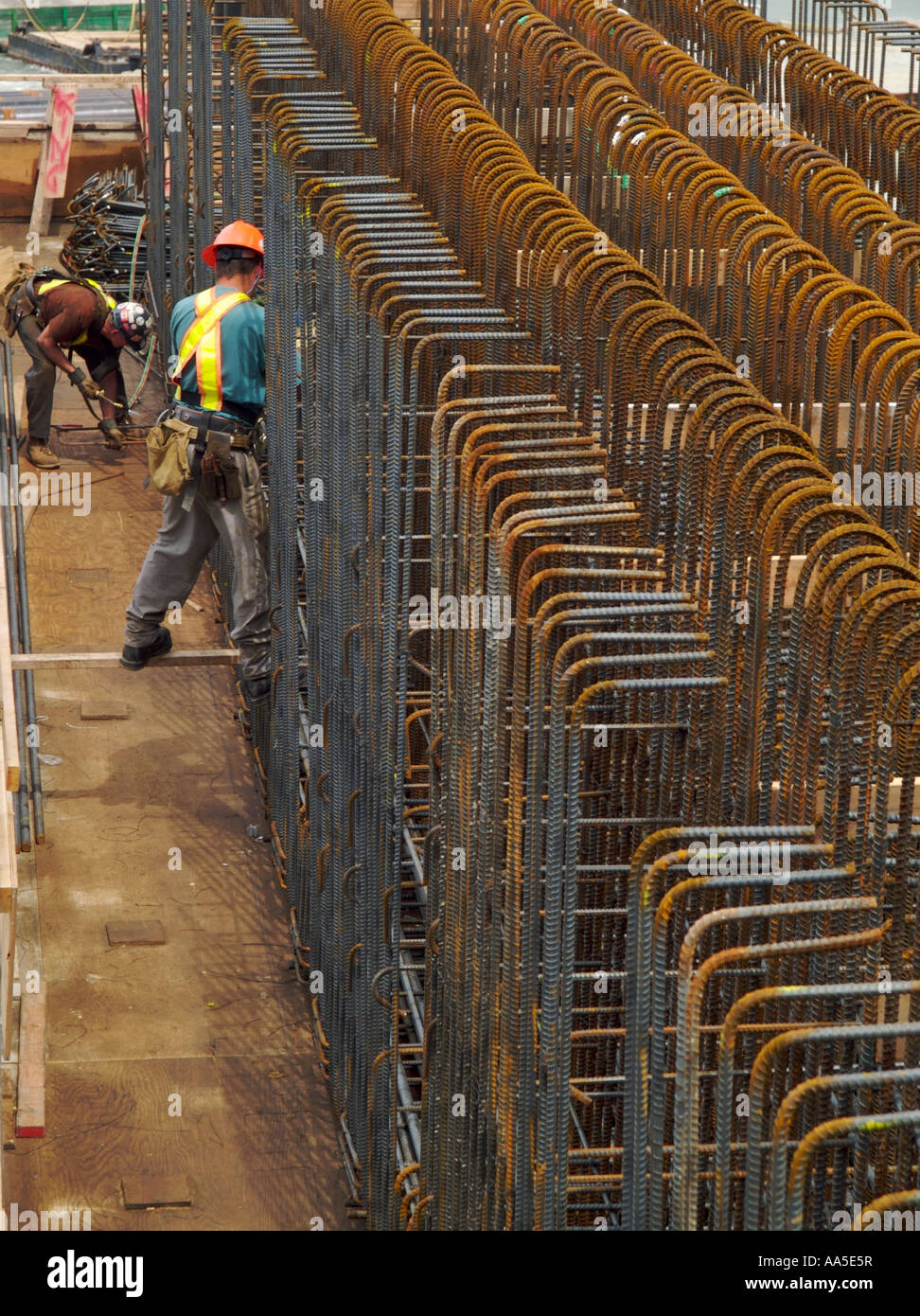 Two steel workers installing steel rebar in new construction on the