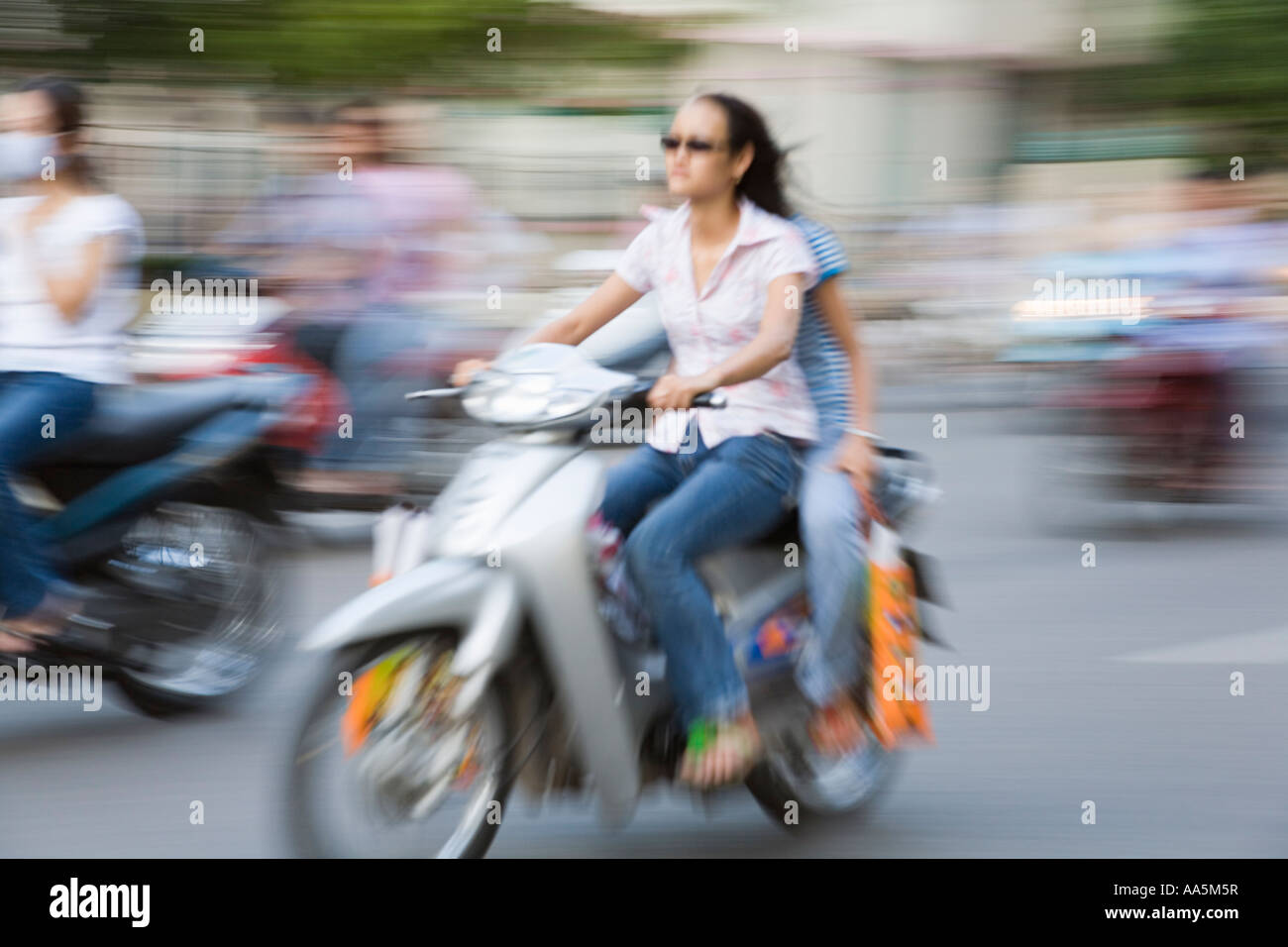 Hanoi, Vietnam. Young women riding a motorbike in the old quarter Stock Photo