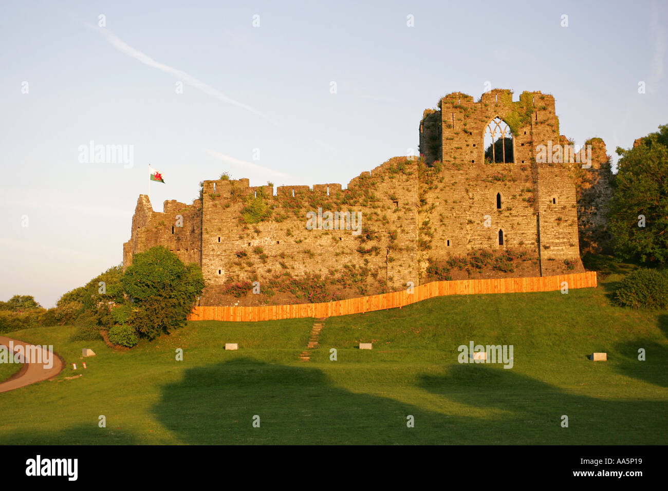 A Welsh national flag flies from Mumbles tourist attraction Oystermouth Castle at sunrise Swansea South Wales UK Britain GB Stock Photo