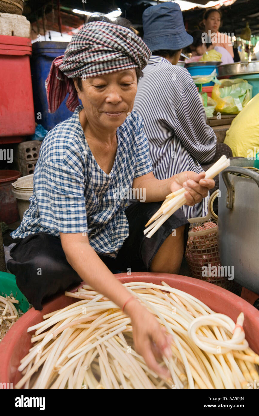 Phnom Penh, Cambodia. Vendor preparing Lotus stems for sale at Psar Thmei central market Stock Photo