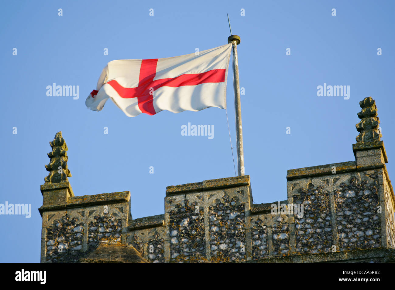 The Saint Georges cross national flag of England flies on top of a typical English village Church tower Wroxham Norfolk England Stock Photo
