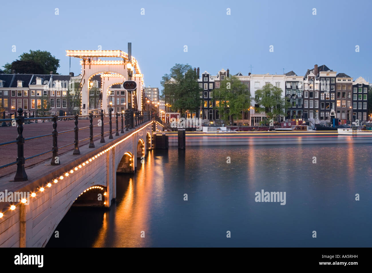 Amsterdam, Netherlands. Magere Brug also known as Skinny Bridge Illuminated at twilight Stock Photo
