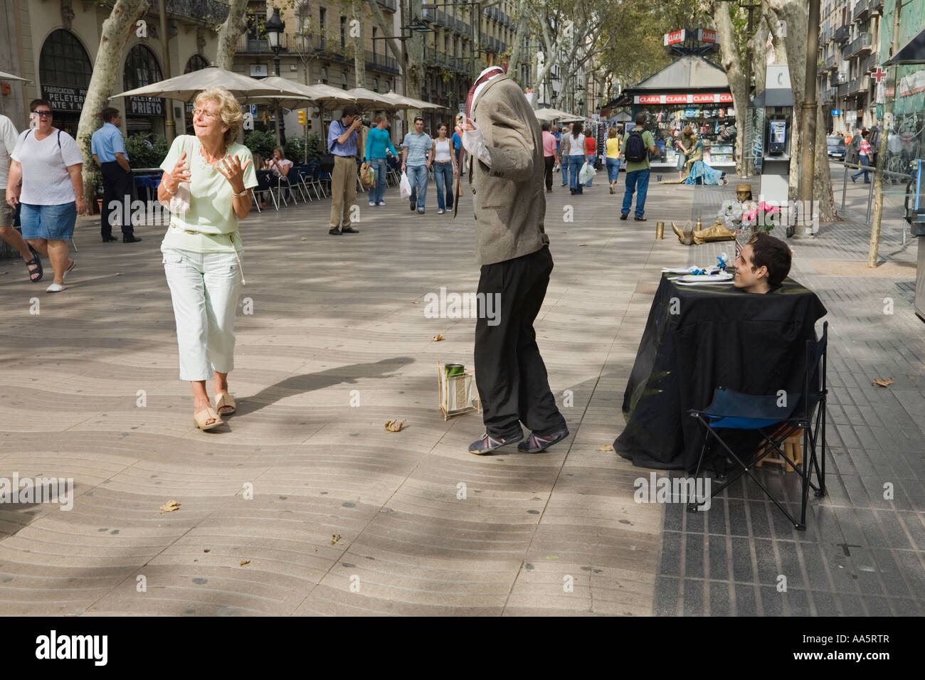 Barcelona, Spain. Headless act, street performers surprise a passerby on La Rambla Stock Photo