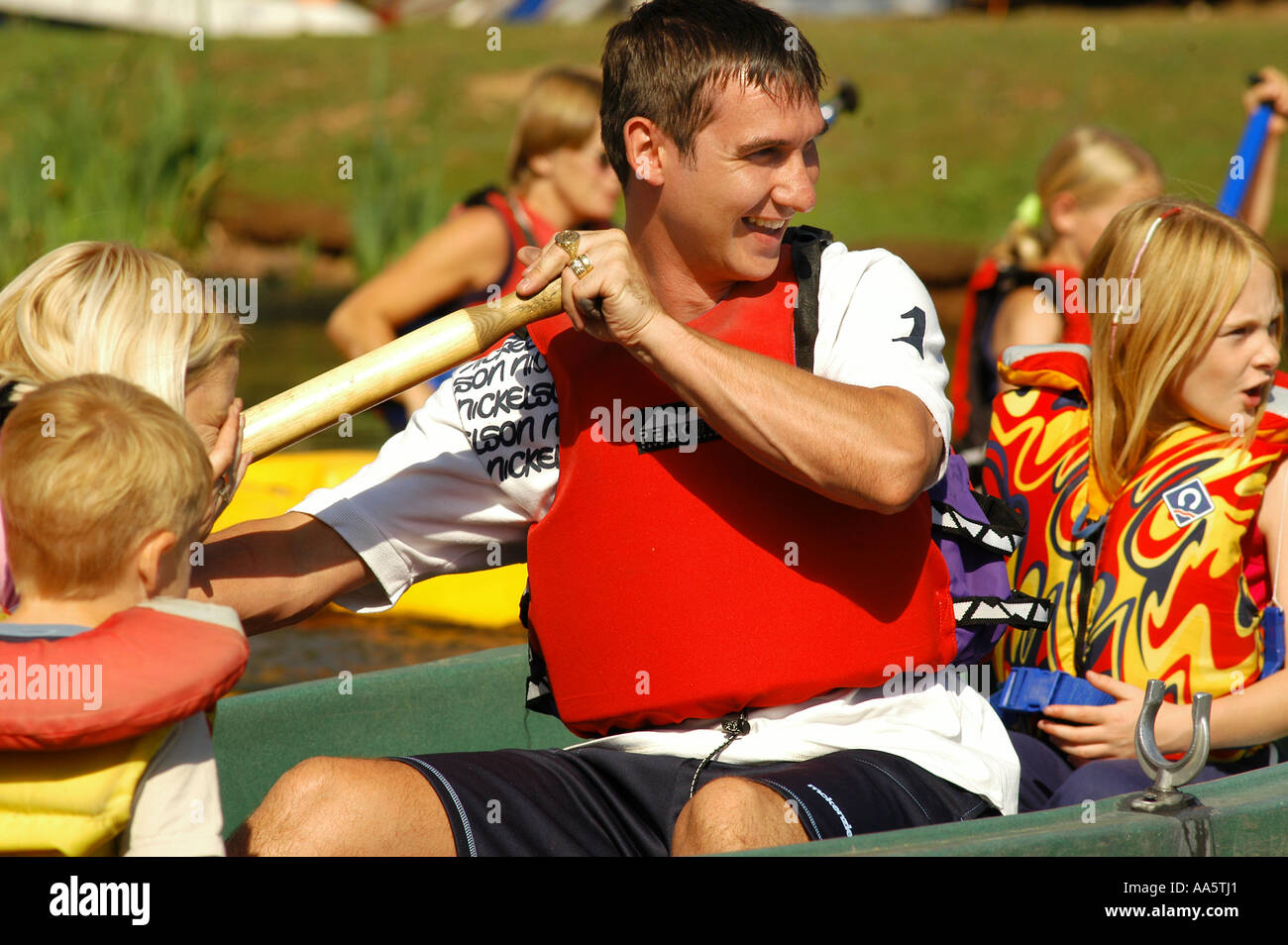 Dad rows on a lake with his family at a Centre Parcs resort in Britain Stock Photo
