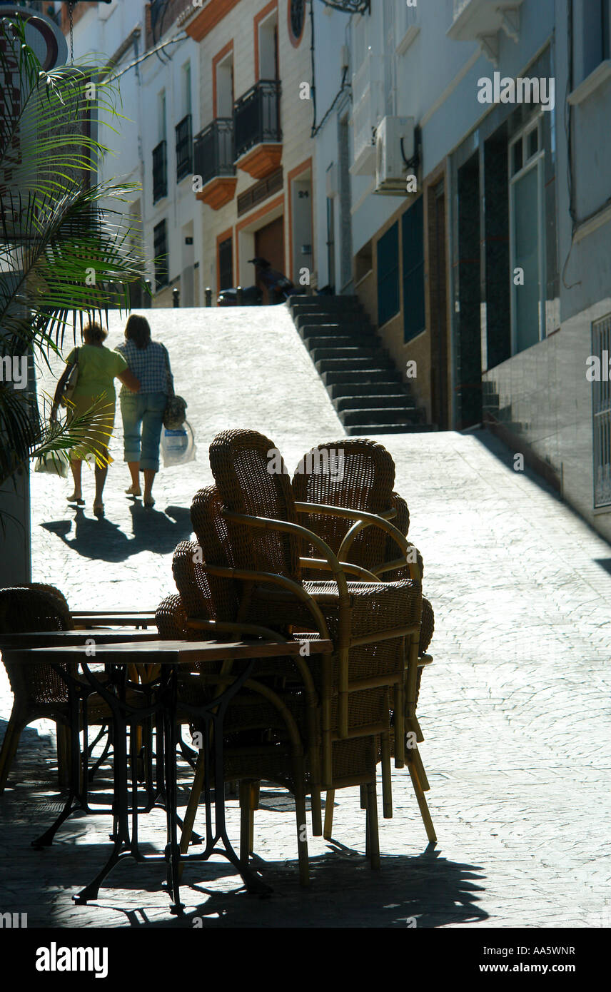 Stacked Chairs outside a bar in a narrow spanish street near Malaga Stock Photo