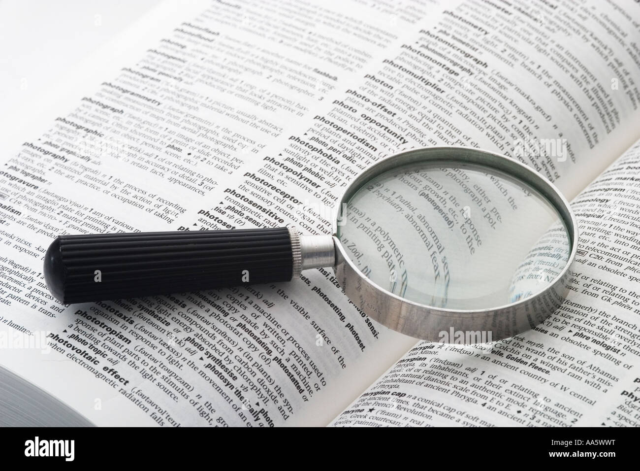 A black and white image of a magnifying glass on an open book Stock ...