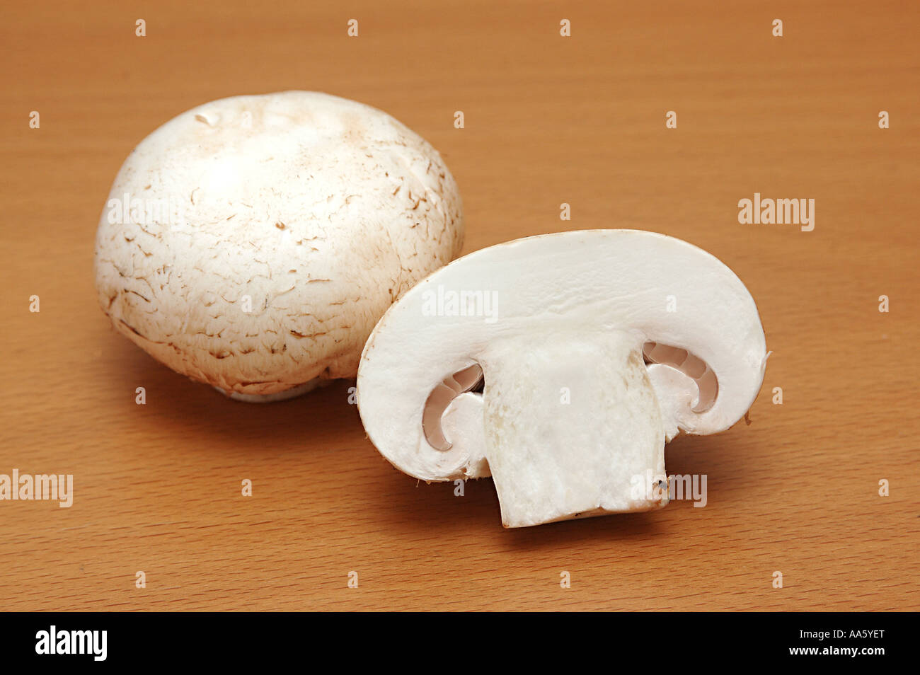 Vegetable white button mushroom cut and chopped shape one full and one half tabletop studio stilllife food Stock Photo
