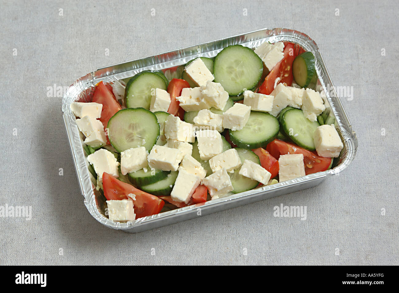 ANG103757 Salad Slices of Cucumber Tomatoes Iceberg salad chopped and cheese kept in aluminum container take away food Stock Photo