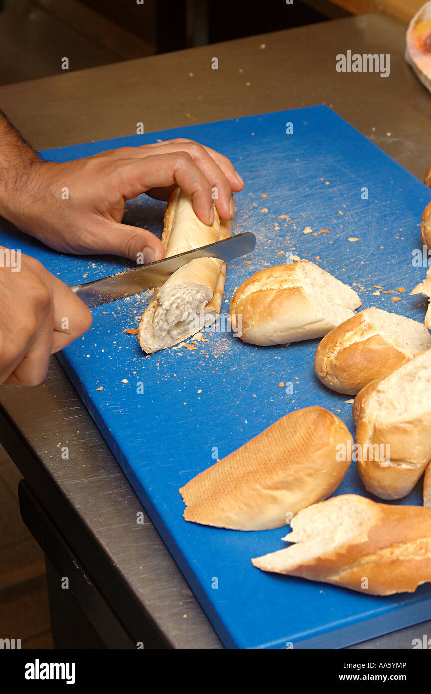 ANG103782 French bread food manual bread cutting by hand Stock Photo