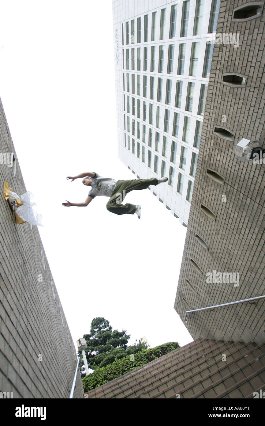 A parkour freerunning athlete jumping between walls in the city. Stock Photo