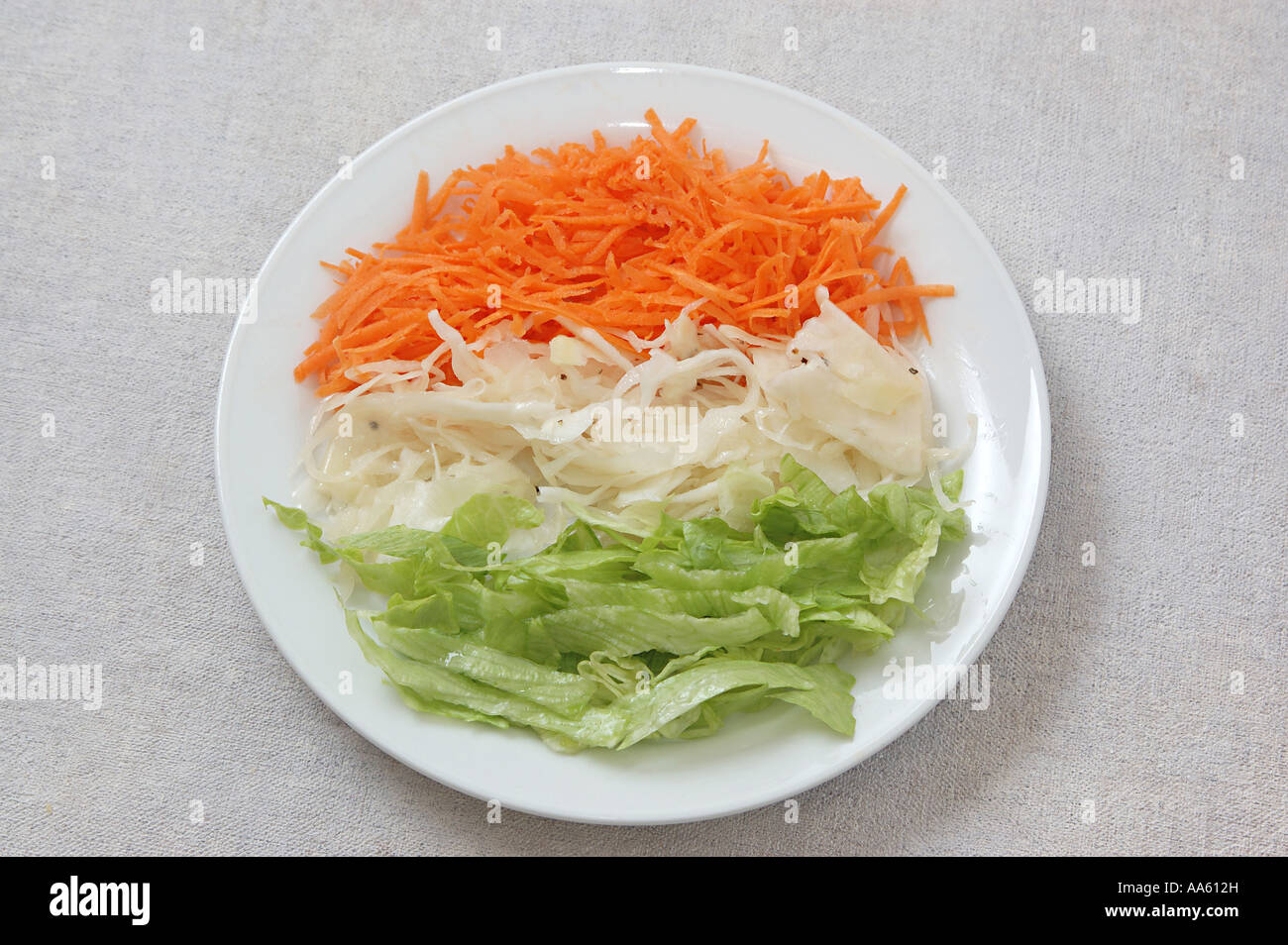 Food salad grated carrot chopped cabbage vinegar black pepper Iceberg salad chopped in round white plate looking Indian Flag Stock Photo