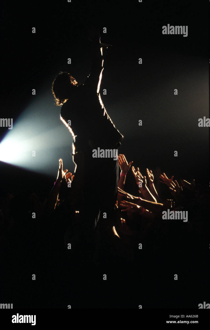 Rear shot of rockstar performing to fans reaching out to him Stock Photo