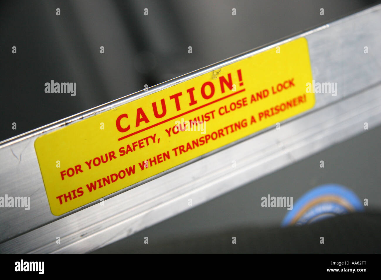 Caution sign about transporting prisoners in the rear of a police car Stock Photo