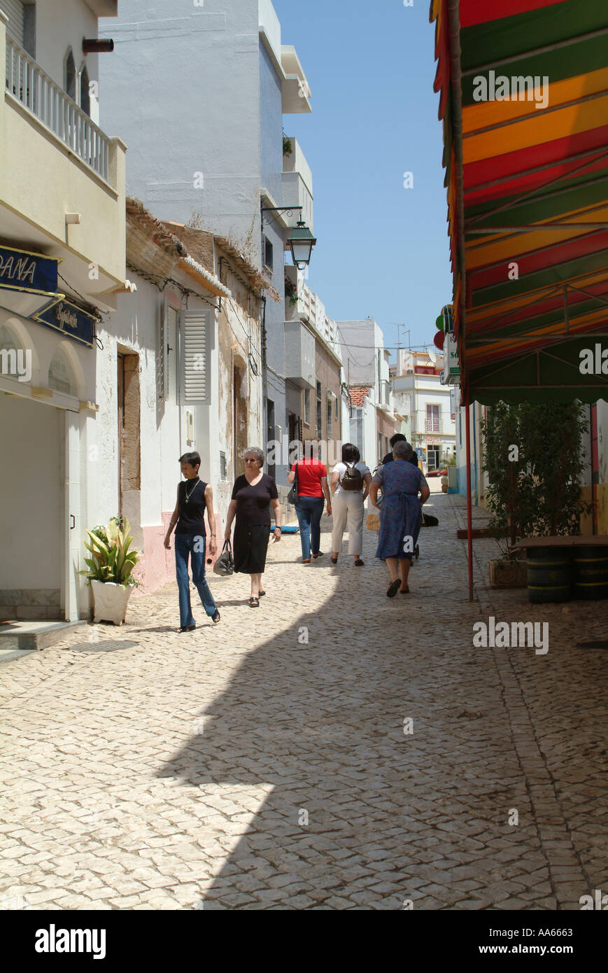 Shoppers and Tourists in Cobbled Street in Alvor Town Algarve Portugal