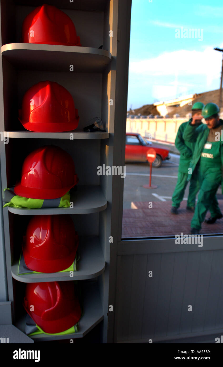 Oil Workers red hard hats sit lined up in the entrance of AzPetrol a transport company that takes oil from tankers on the Stock Photo