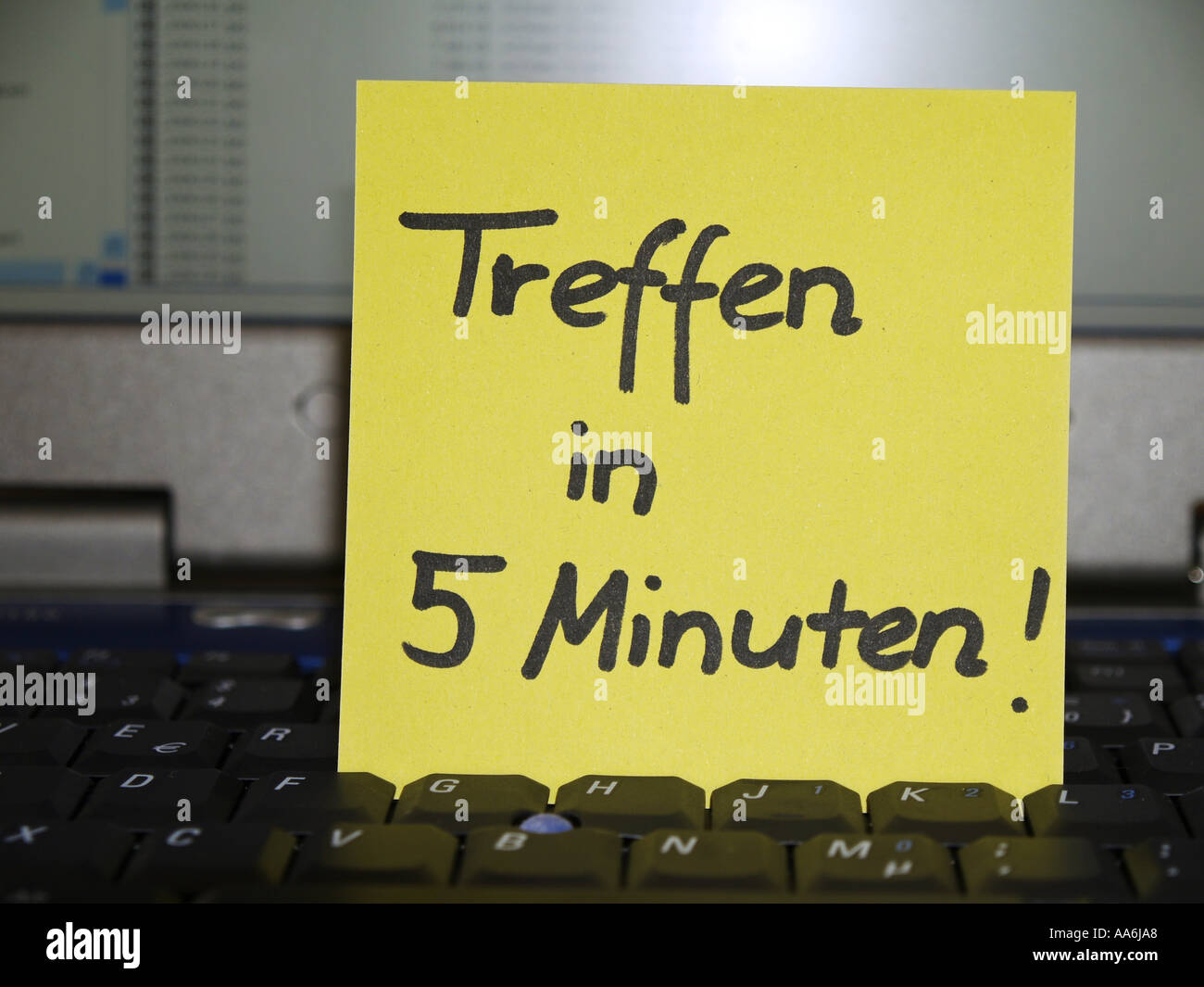 memo note on notebook, meeting in five minutes Stock Photo