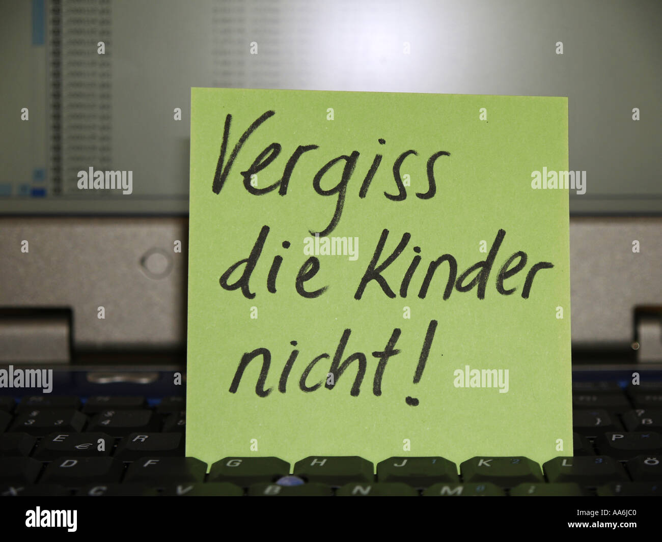 memo note on notebook Vergiss die Kinder nicht don t forget the kids Stock Photo