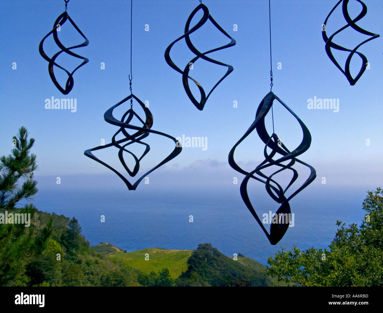 Copper mobiles hanging on display against a view over the Pacific ocean The Big Sur California USA Stock Photo