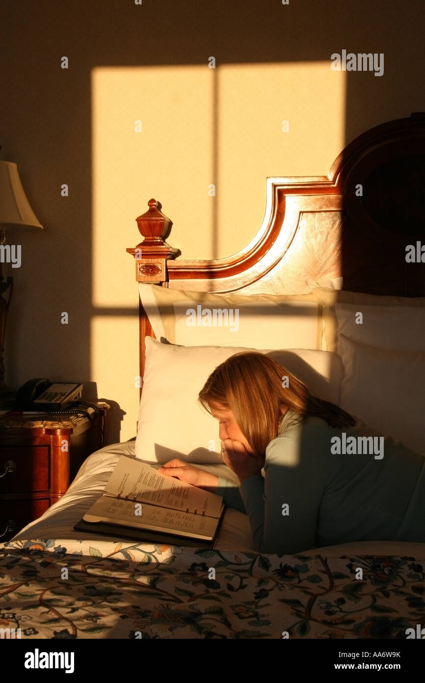 Reading the Hotel Directory in bed Stock Photo