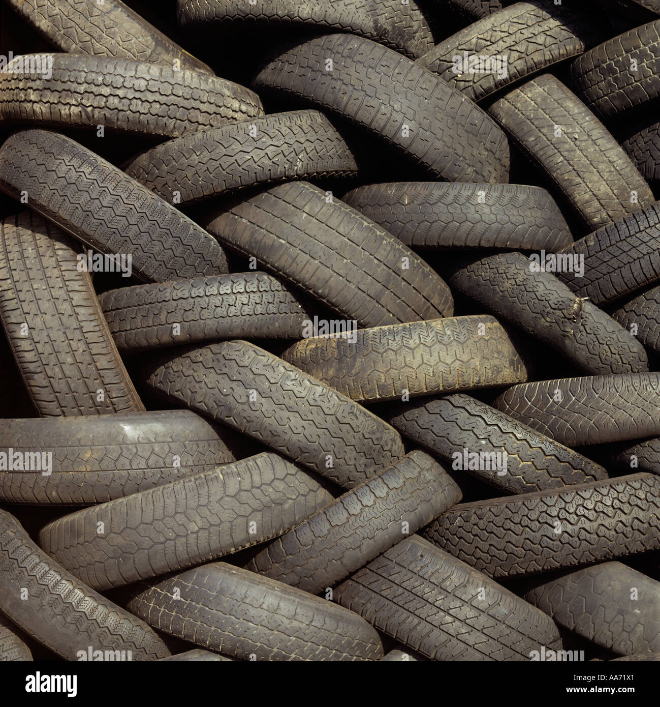 Rubber motor vehicle tyres stacked at a waste transfer station before being recycled Stock Photo