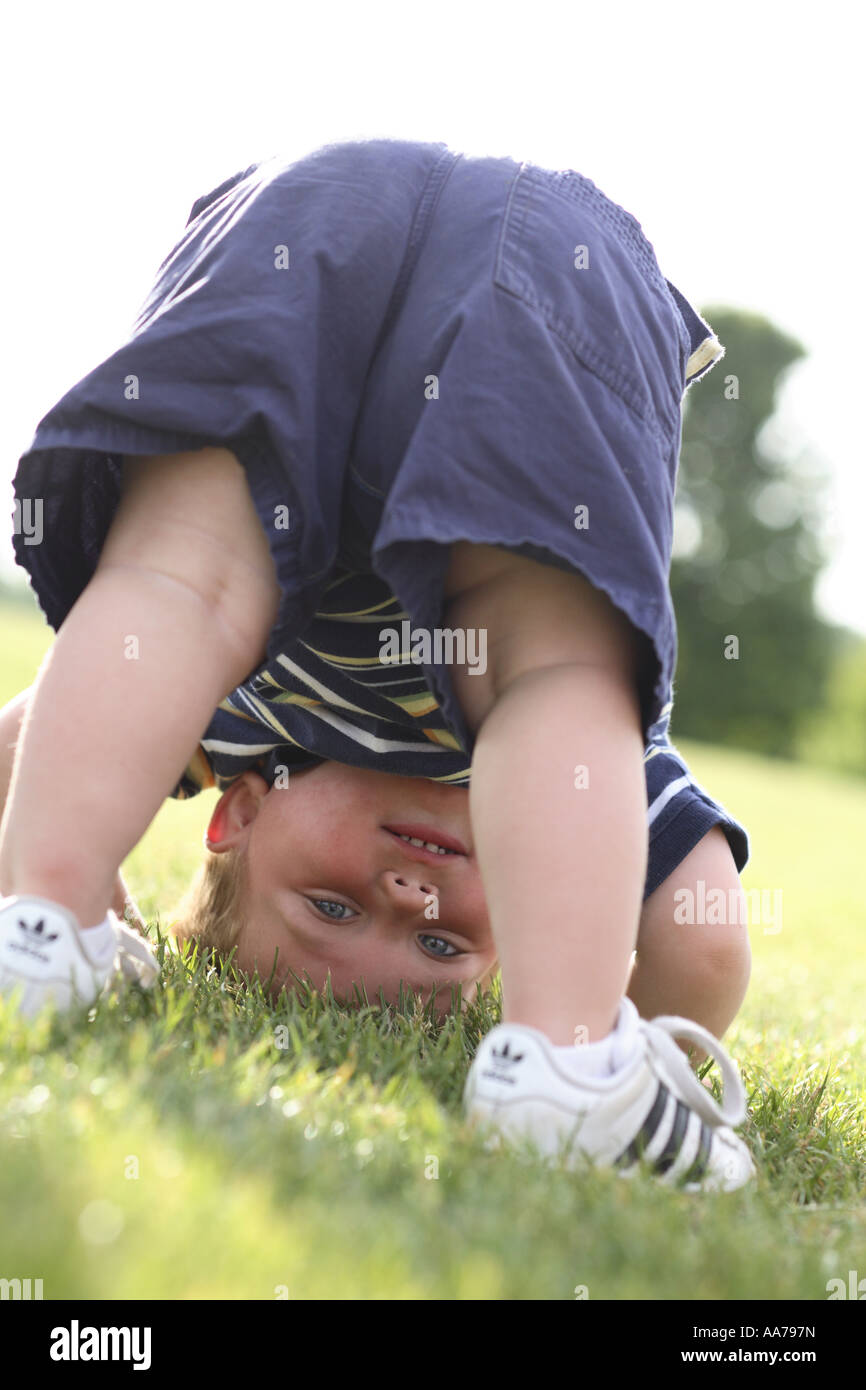One year old boy upside down looking through legs Stock Photo