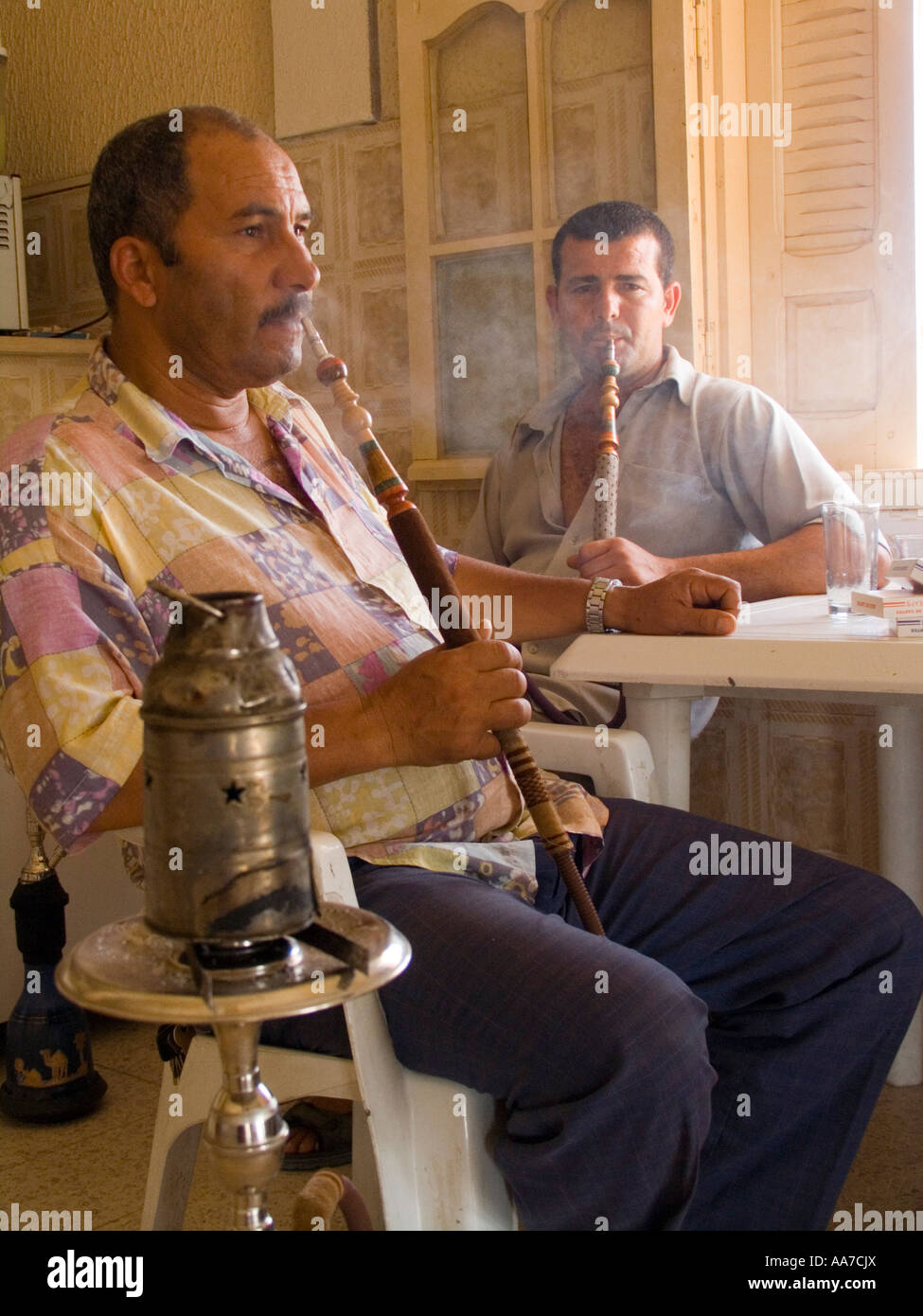 Two men smoking water pipes in a roadside cafe Tunisia Stock Photo Alamy