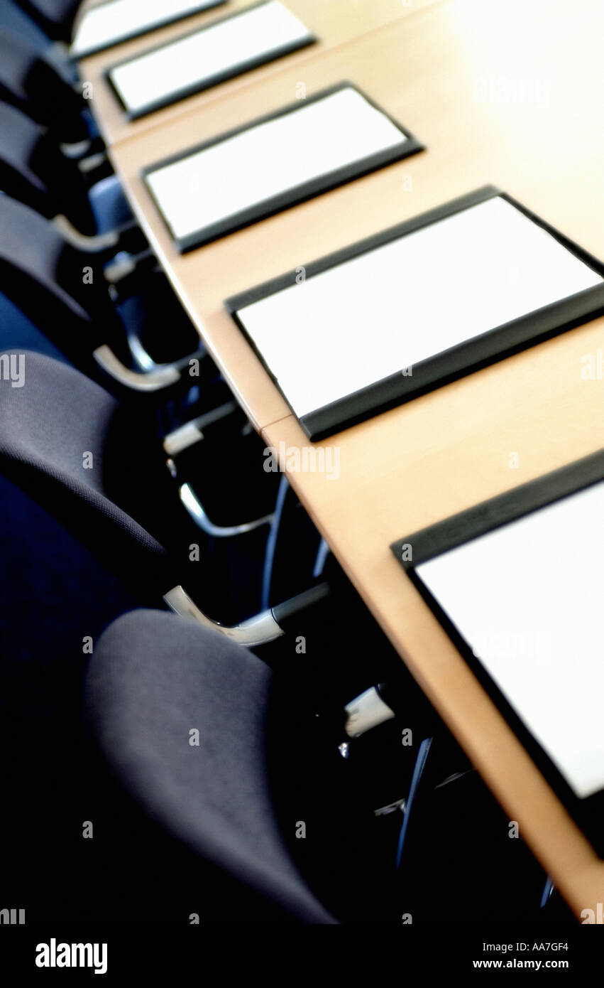Chairs And Blotter Pads On Desk In Empty Boardroom Stock Photo