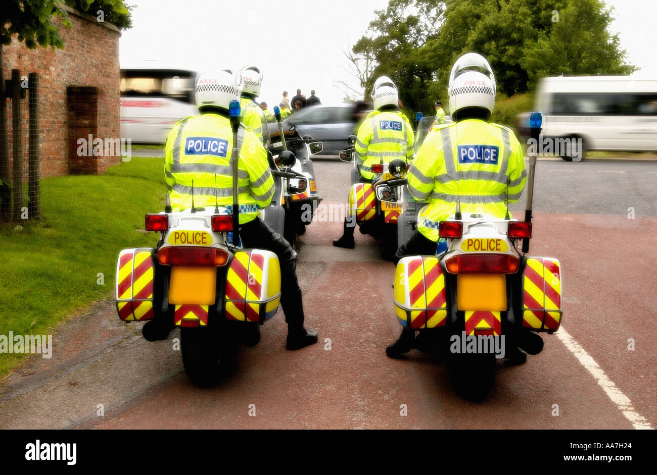 Police officers on motorbikes wait down a side street for Royal convoy to pass in order to escort it through traffic Stock Photo