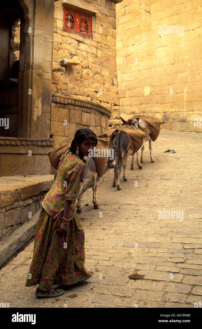 Young female Indian donkey herder following animals into Jaisalmer Fort, Rajasthan, North India Stock Photo