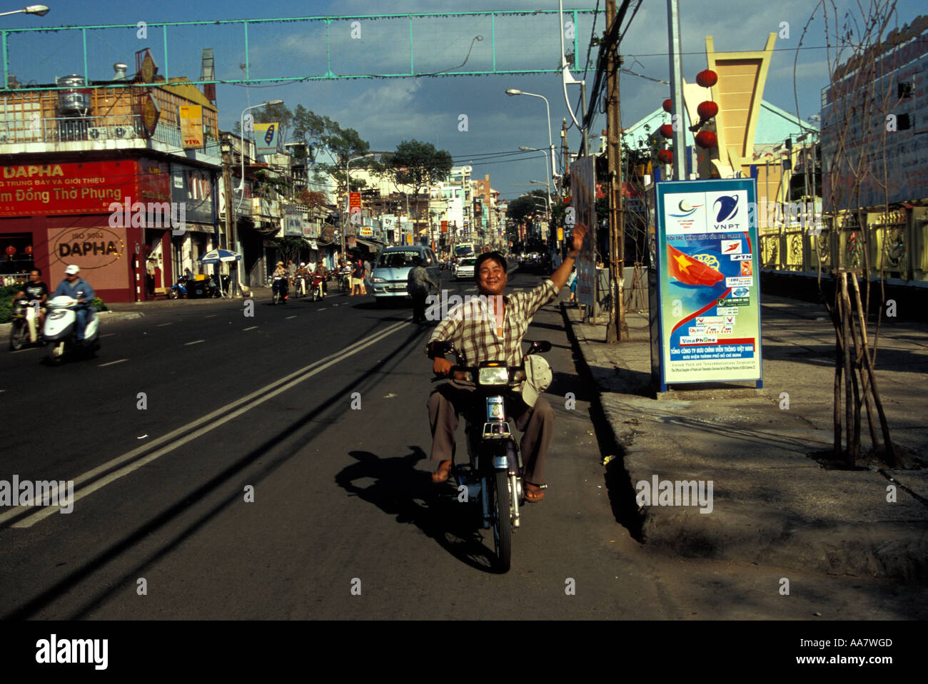 Man on motorbike waving arm in air, Ho Chi Minh City, Vietnam Stock Photo