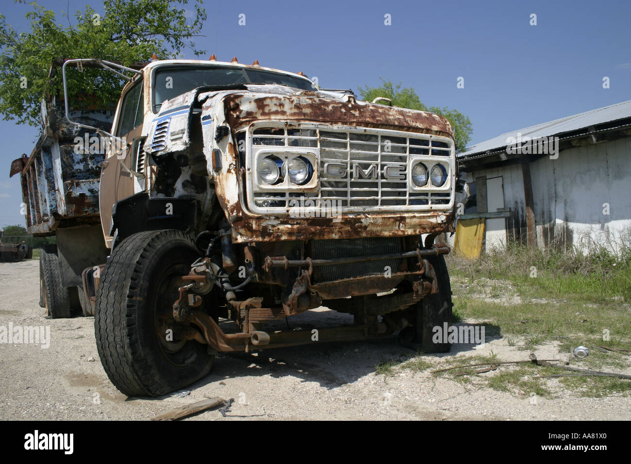 a dump truck lies idle outside of a junkyard Stock Photo Alamy