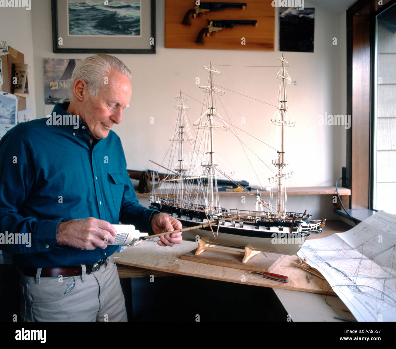 Senior citizen model builder working in his home studio constructing a
