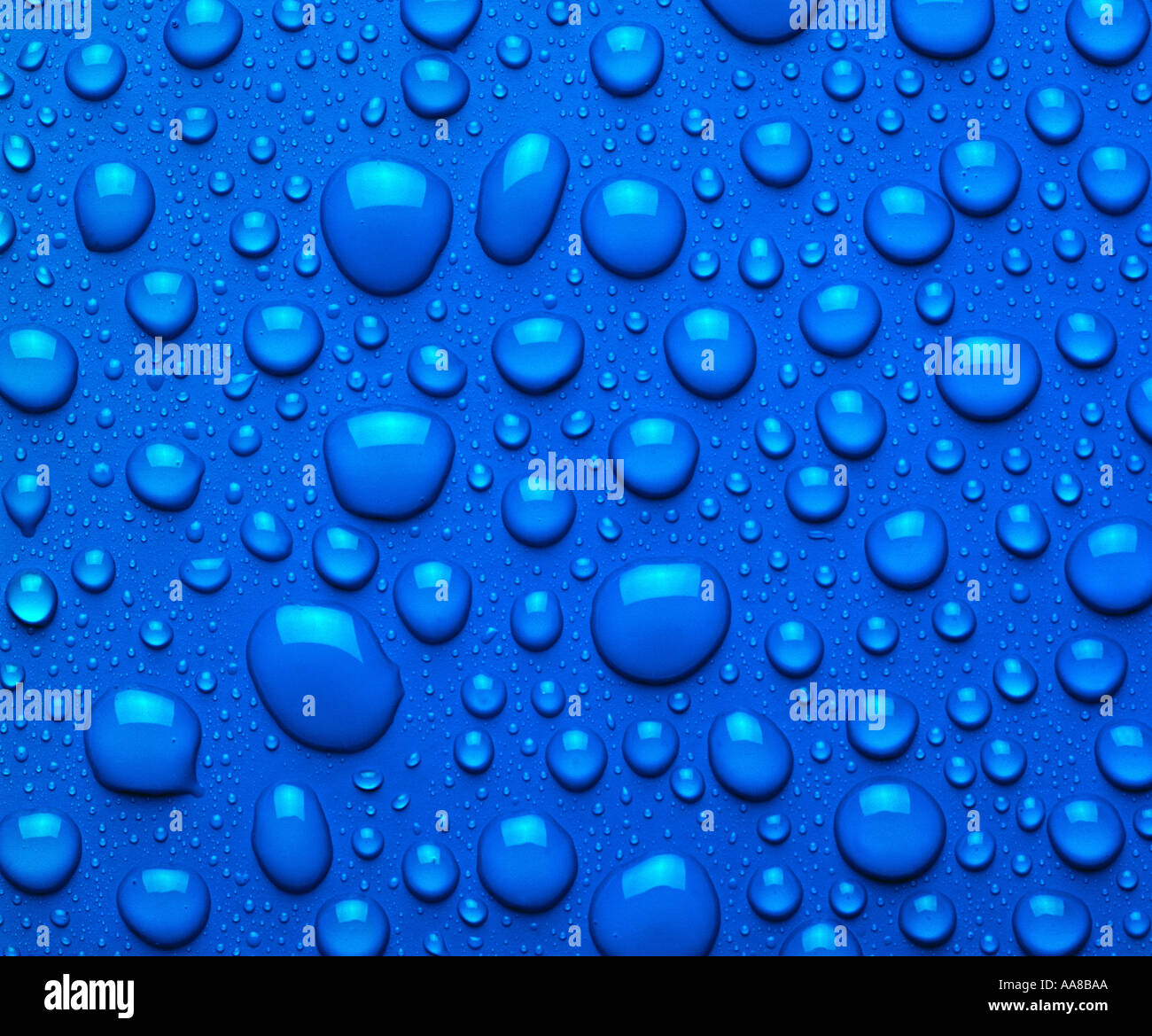 BLUE WATER DROPLETS ON BLUE SURFACE Stock Photo