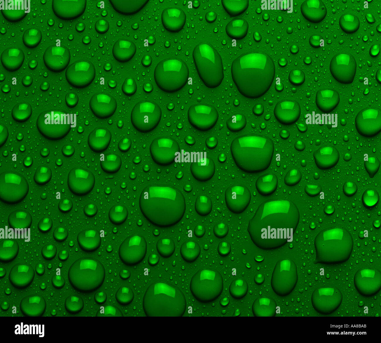 DROPLETS OF GREEN LIQUID ON GREEN SURFACE Stock Photo