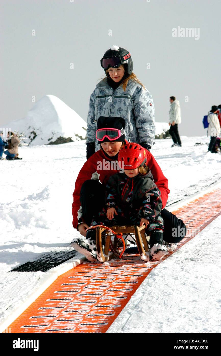 Family on a moving carpet ski lift Grimentz Switzerland Stock Photo - Alamy
