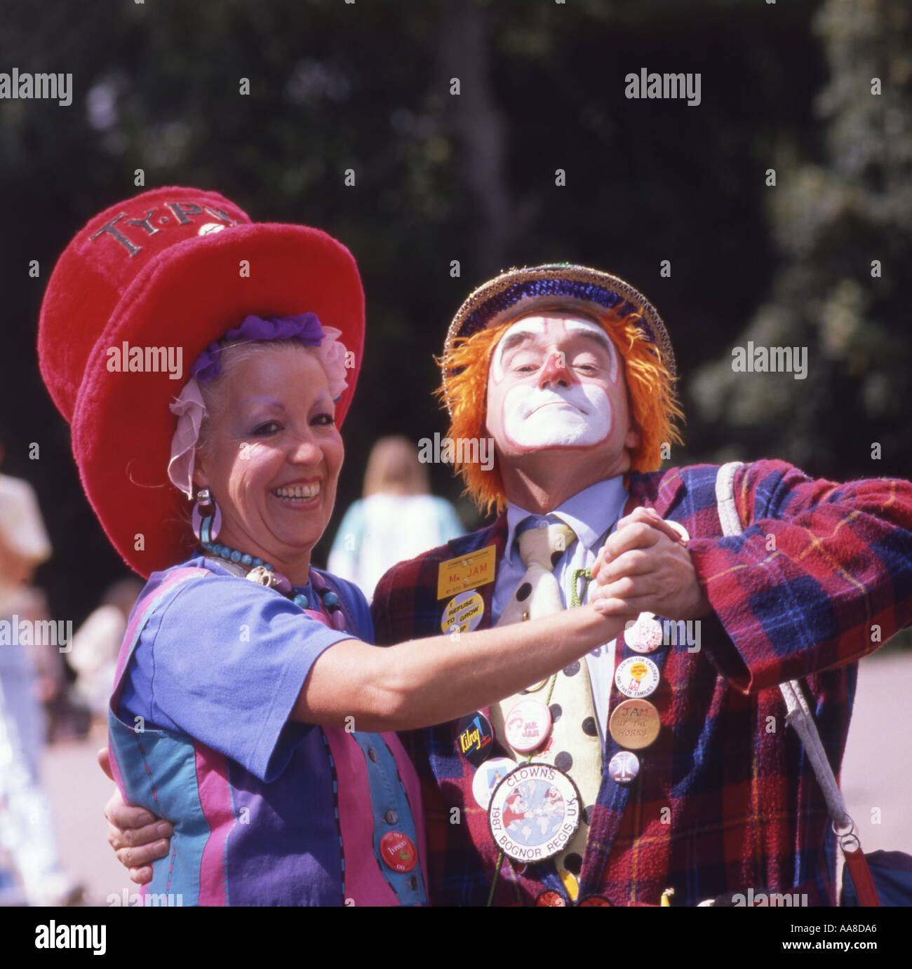 Smiling middle aged woman dancing with clown Stock Photo - Alamy