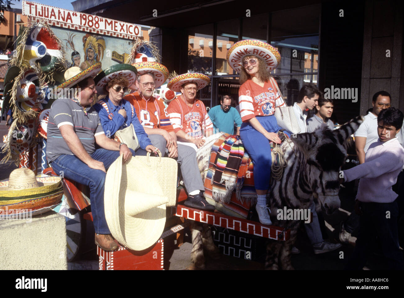 American tourists pose for picture with donkey painted like a zebra on